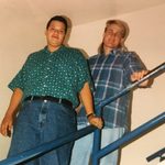 Two students pose on a stairway