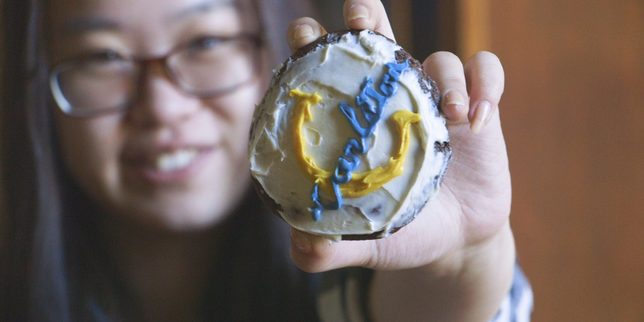 A student holds up a cookie