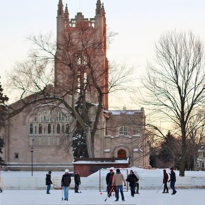 A broomball game on the bald spot ice rink, with Skinner Chapel in the background
