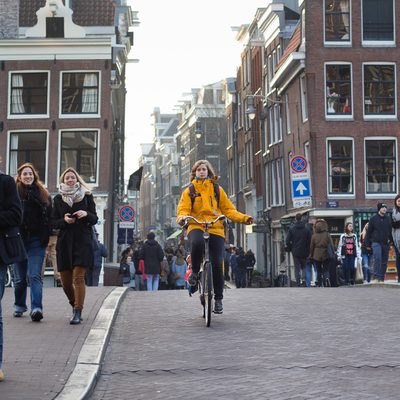 A woman on a bike in a busy Amsterdam street