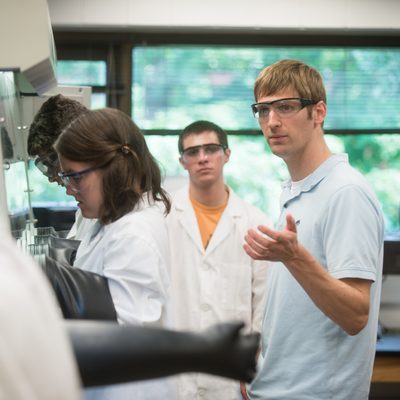 Chemistry professor Matt Whited watches over students in the Carleton science research lab.