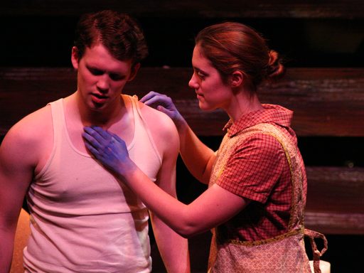 A woman with blue hands touching the chest of a man